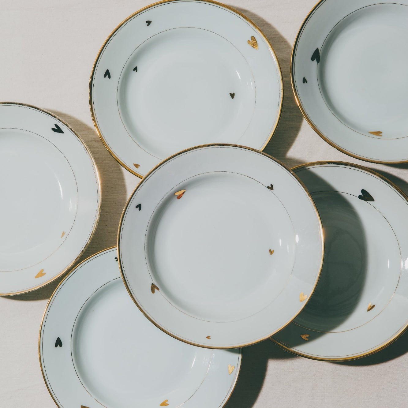 Cette photo représente une assiette qui a été décorée au décalcomanie avec des petits cœurs en or lors d'un atelier de décor au décalcomanie à l'atelier grand soleil à Paris dans le 11e.