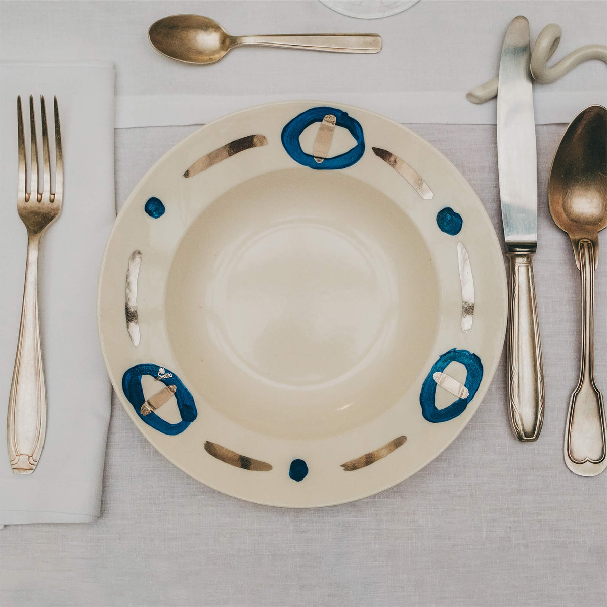 Assiette en porcelaine décorée au platine par l'atelier grand soleil, à Paris. Thème Art Déco.
