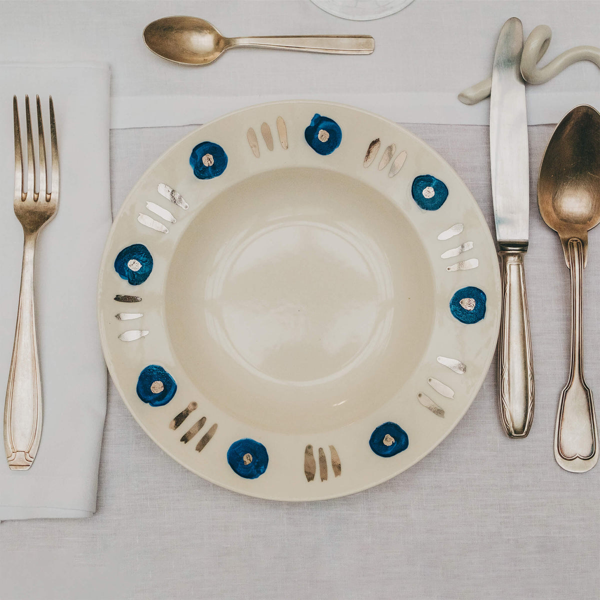 Assiette en porcelaine décorée au platine par l'atelier grand soleil, à Paris. Thème Art Déco.