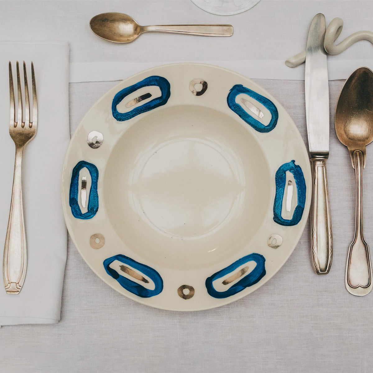 Assiette en porcelaine décorée au platine par l'atelier grand soleil, à Paris. Thème Art Déco.