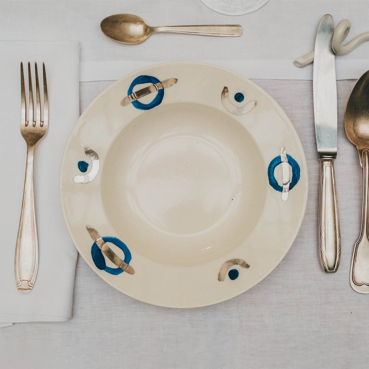 Assiette en porcelaine décorée au platine par l'atelier grand soleil, à Paris. Thème Art Déco.