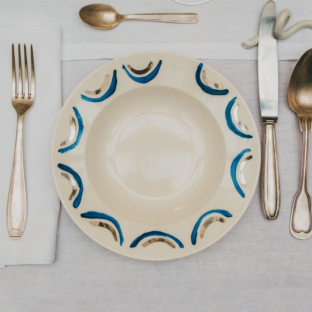 Assiette en porcelaine décorée au platine par l'atelier grand soleil, à Paris. Thème Art Déco.
