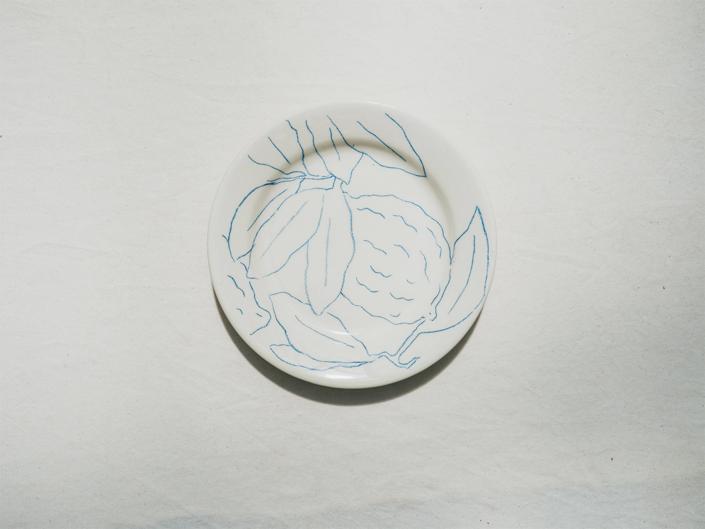 Assiette en faience décorée au crayon à oxydes puis émaillée par l'atelier grand soleil, à Paris. Personnalisable avec une phrase. Motif : cédrat