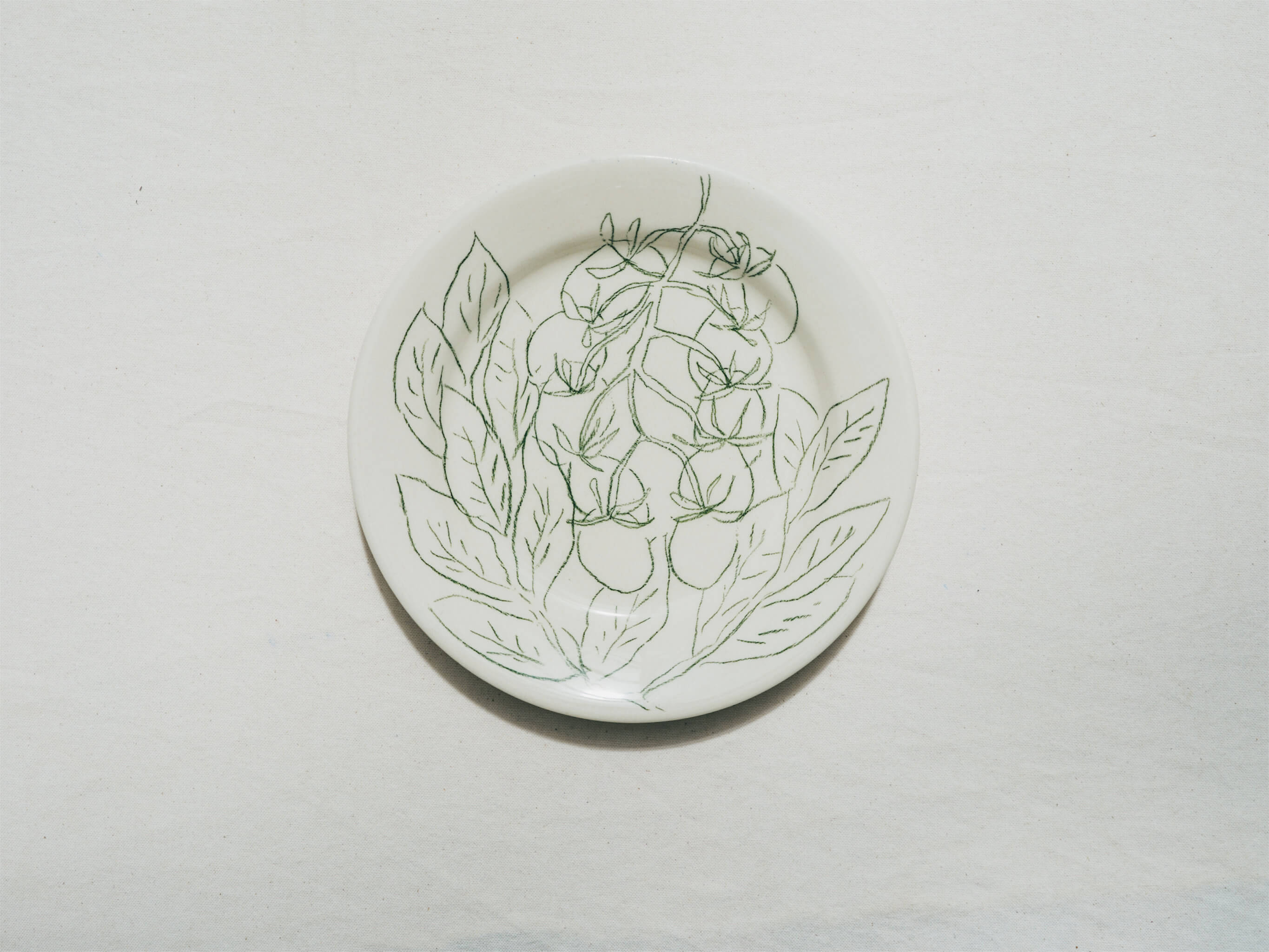 Assiette en faience décorée au crayon à oxydes puis émaillée par l'atelier grand soleil, à Paris. Personnalisable avec une phrase. Motif : tomates et basilic