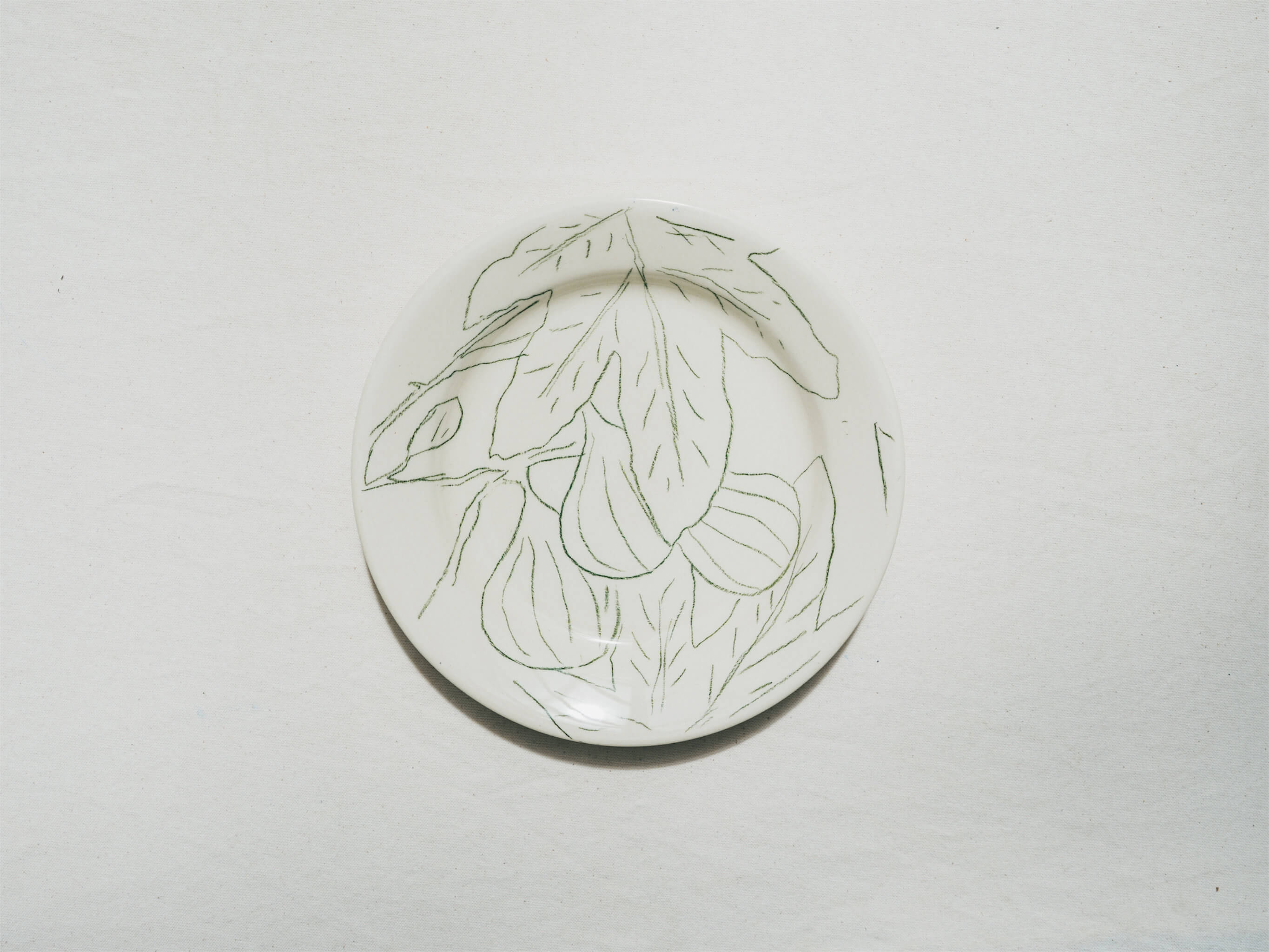 Assiette en faience décorée au crayon à oxydes puis émaillée par l'atelier grand soleil, à Paris. Personnalisable avec une phrase. Motif : figues