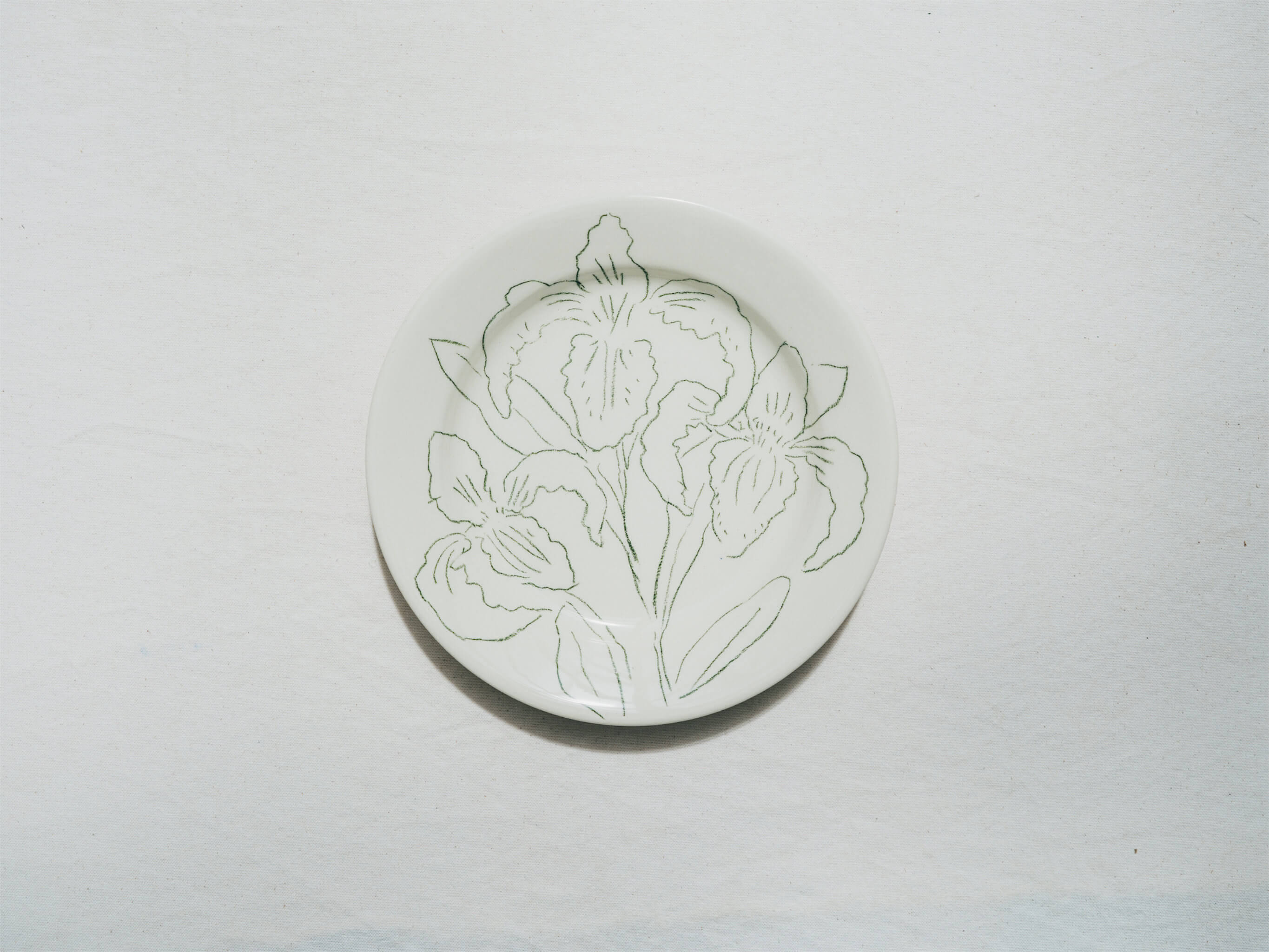 Assiette en faience décorée au crayon à oxydes puis émaillée par l'atelier grand soleil, à Paris. Personnalisable avec une phrase. Motif : lys