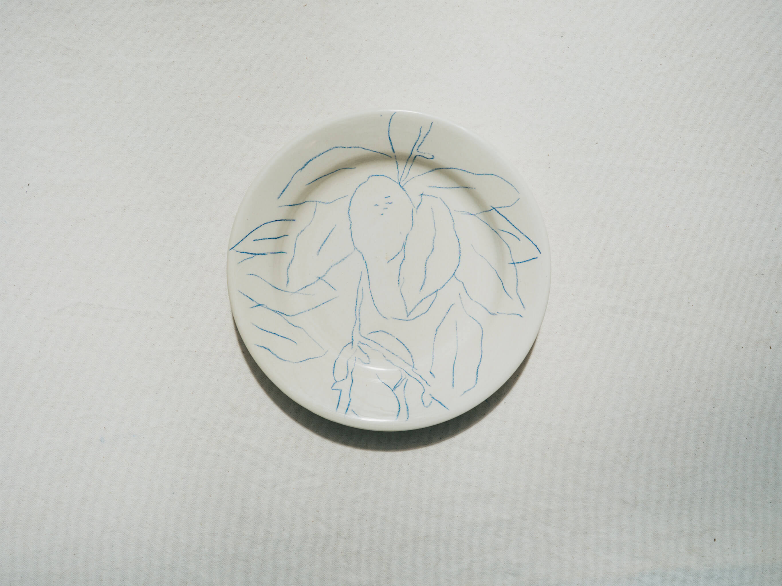 Assiette en faience décorée au crayon à oxydes puis émaillée par l'atelier grand soleil, à Paris. Personnalisable avec une phrase. Motif : pêche plate