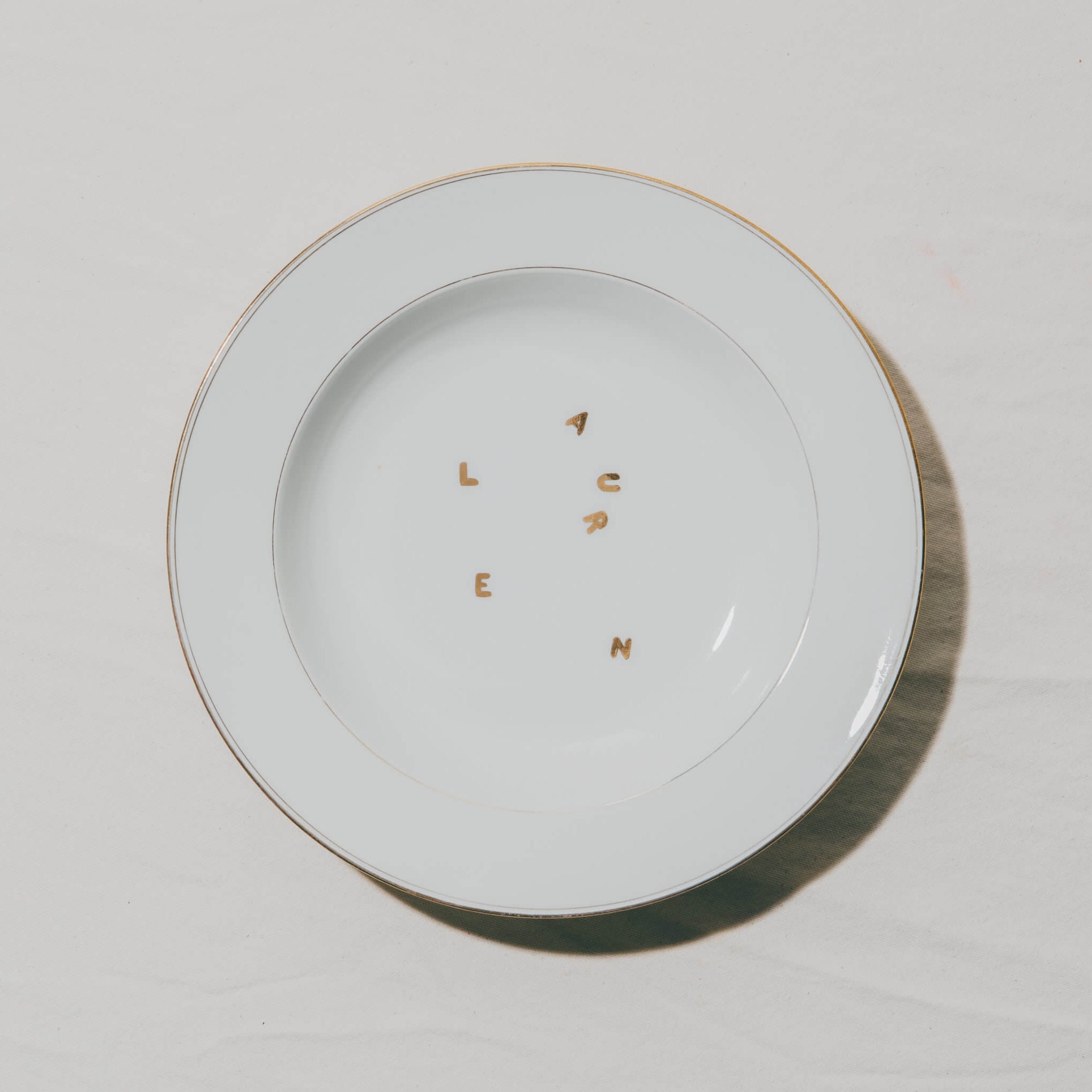 assiette en porcelaine décorée à l'or et à la plume, réalisée sur commande, personnalisable à la demande, à l'atelier Grand Soleil à Paris