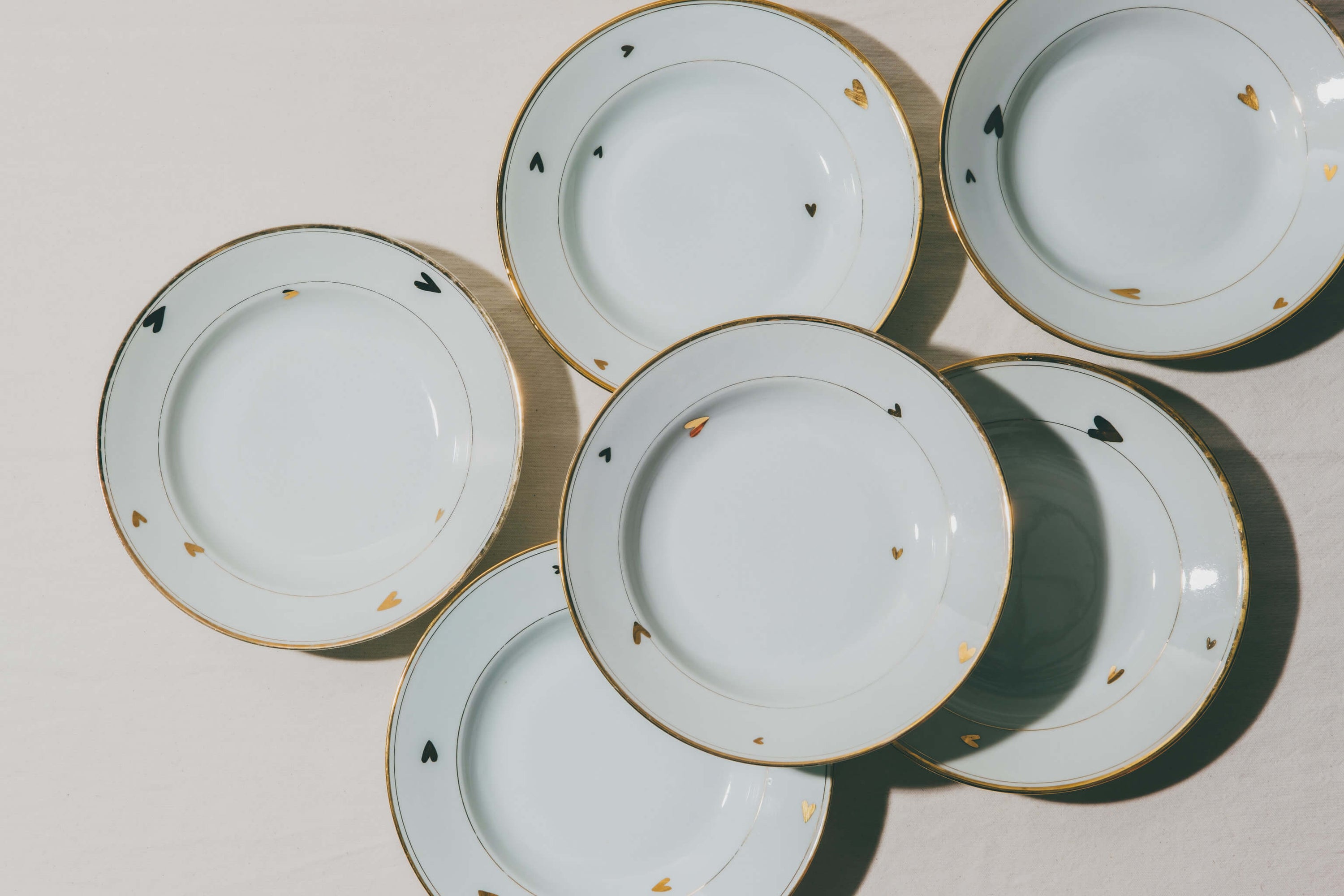assiettes en porcelaine décorées à l'or et à la plume, réalisées sur commande, personnalisables à la demande, par l'atelier Grand Soleil à Paris