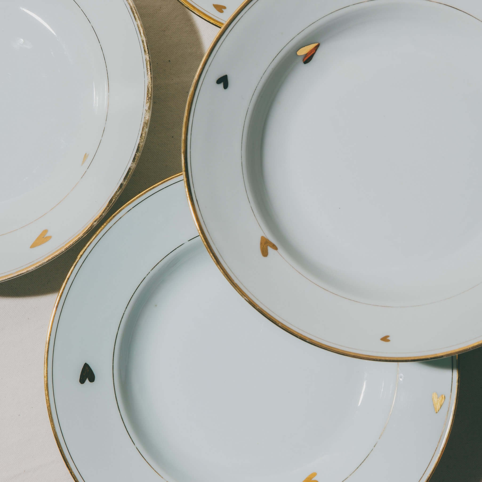 assiettes en porcelaine décorées à l'or et à la plume, réalisées sur commande, personnalisables à la demande, par l'atelier Grand Soleil à Paris