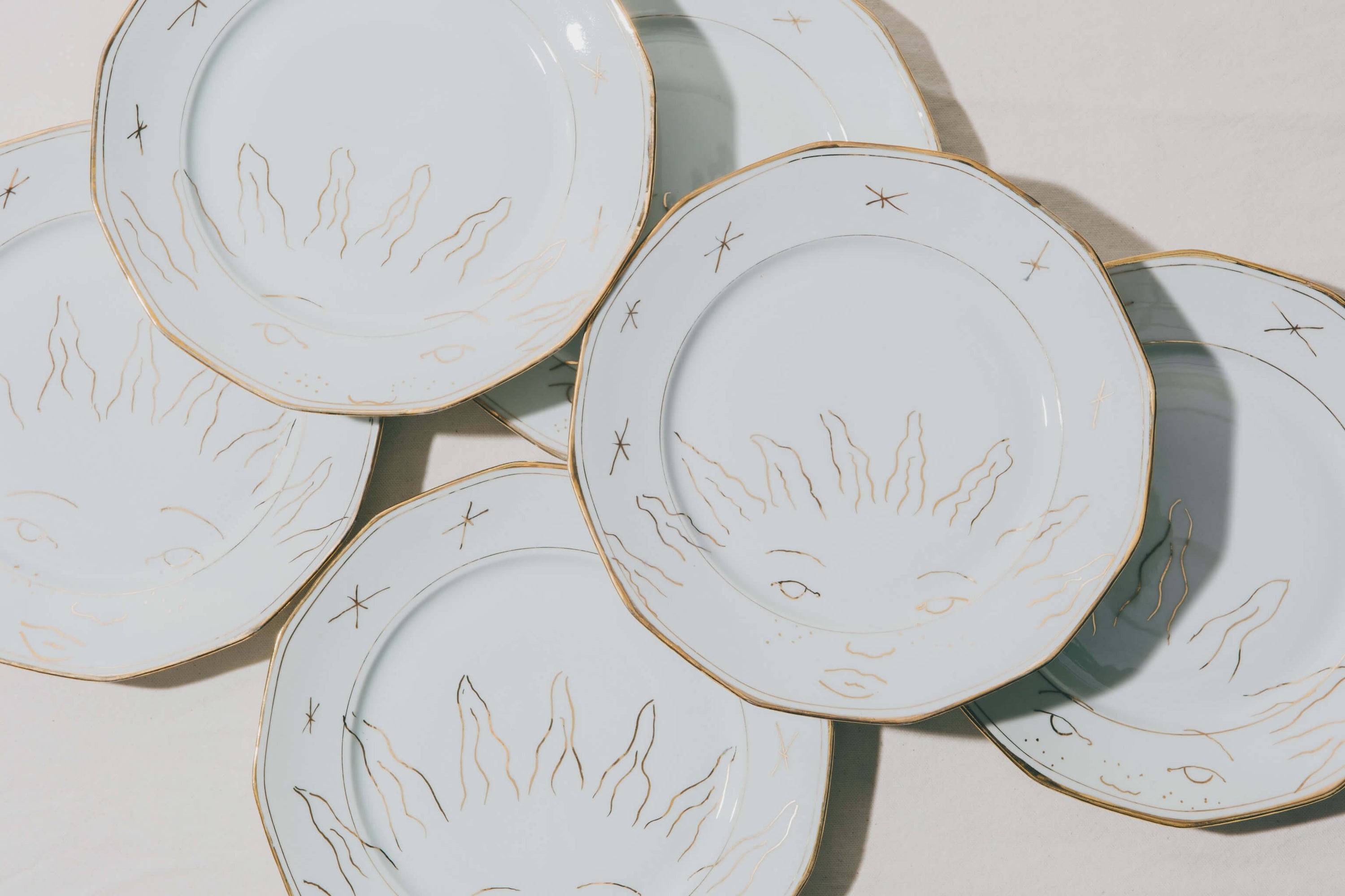 assiettes en porcelaine décorées à l'or et à la plume, réalisées sur commande, personnalisables à la demande, par l'atelier Grand Soleil à Paris
