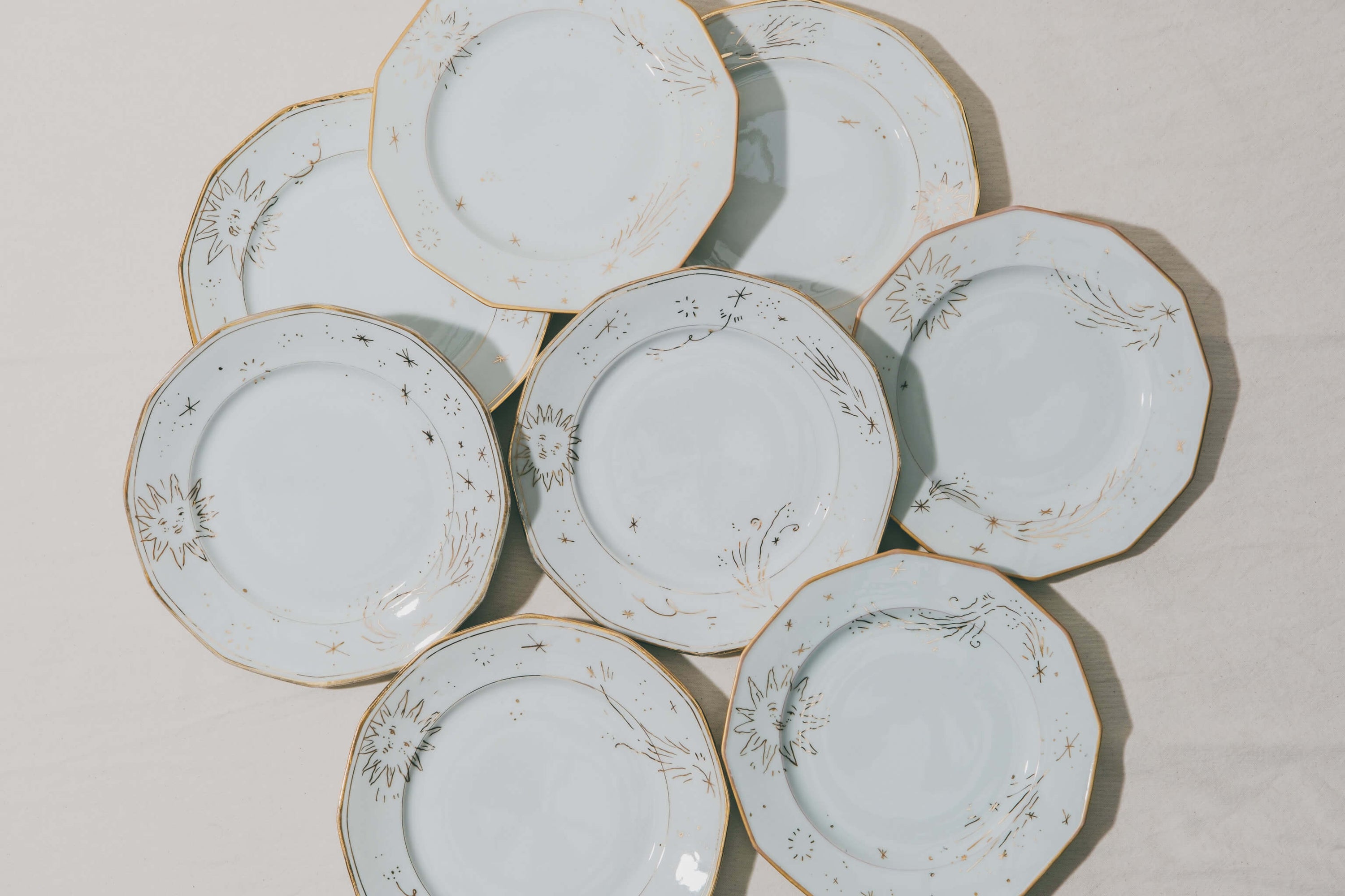 Assiettes en porcelaine vintage décorées à la main à l'or et à la plume par l'atelier Grand Soleil à Paris, personnalisables sur demande