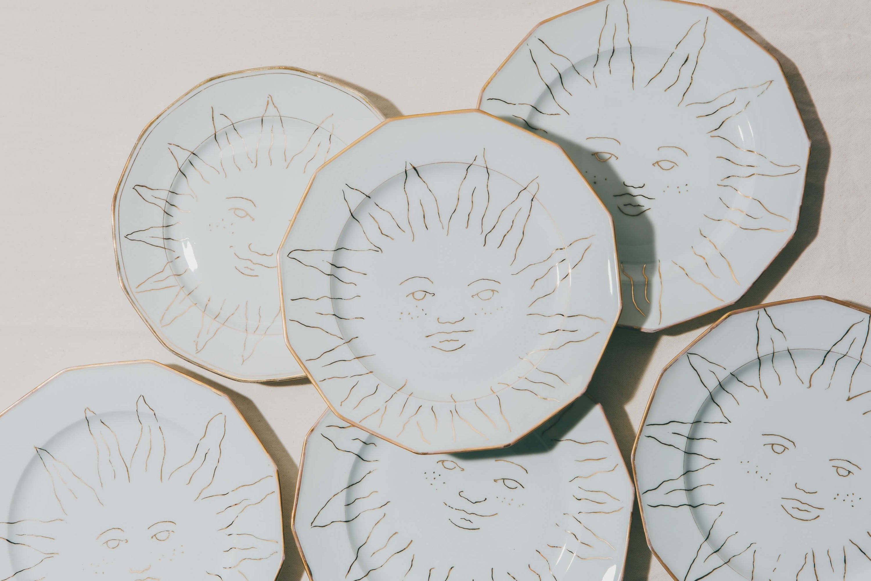 Assiettes en porcelaine vintage décorées à la main à l'or et à la plume par l'atelier Grand Soleil à Paris, personnalisables sur demande