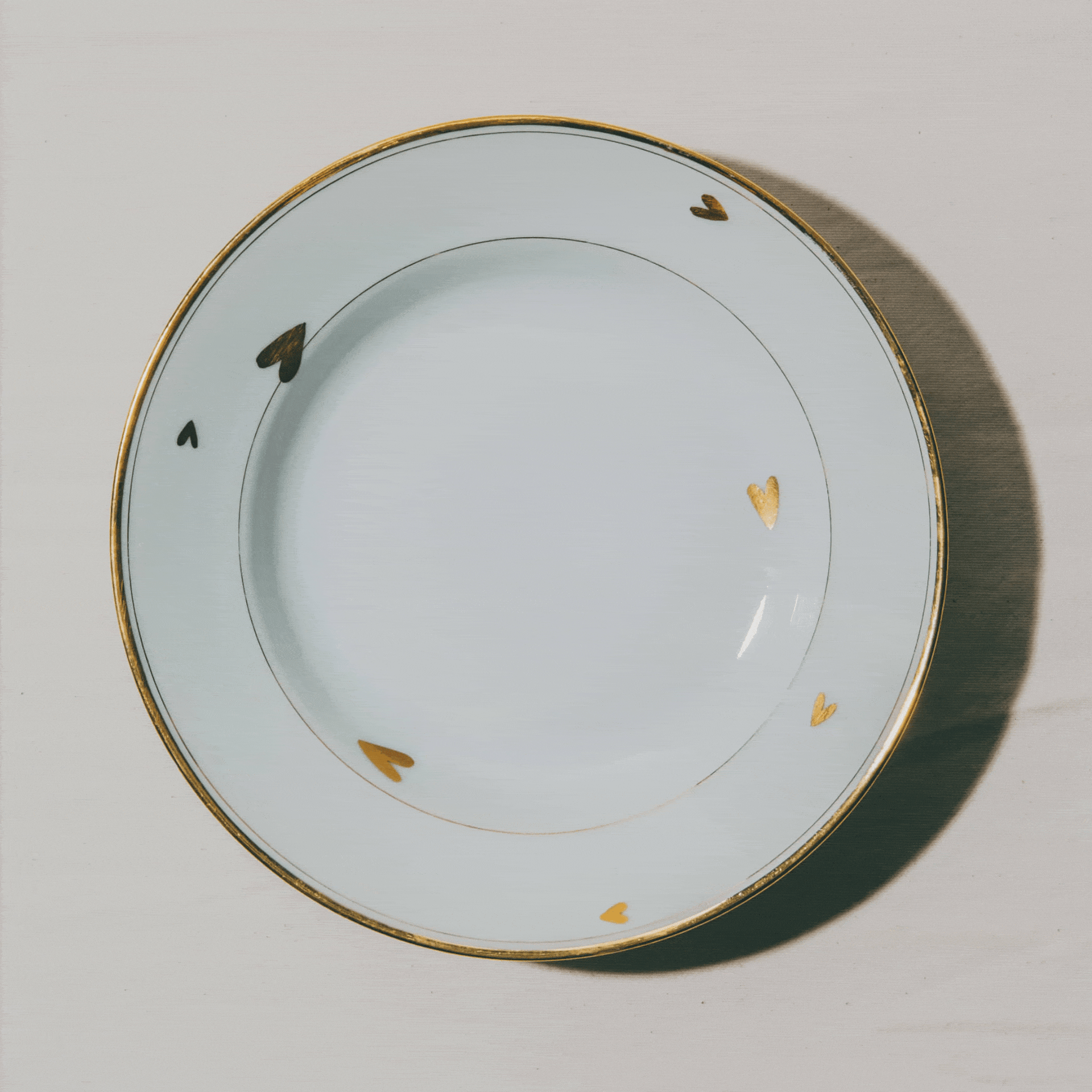 assiettes en porcelaine décorées à l'or et à la plume, réalisées sur commande, personnalisables à la demande, par l'atelier Grand Soleil à Paris