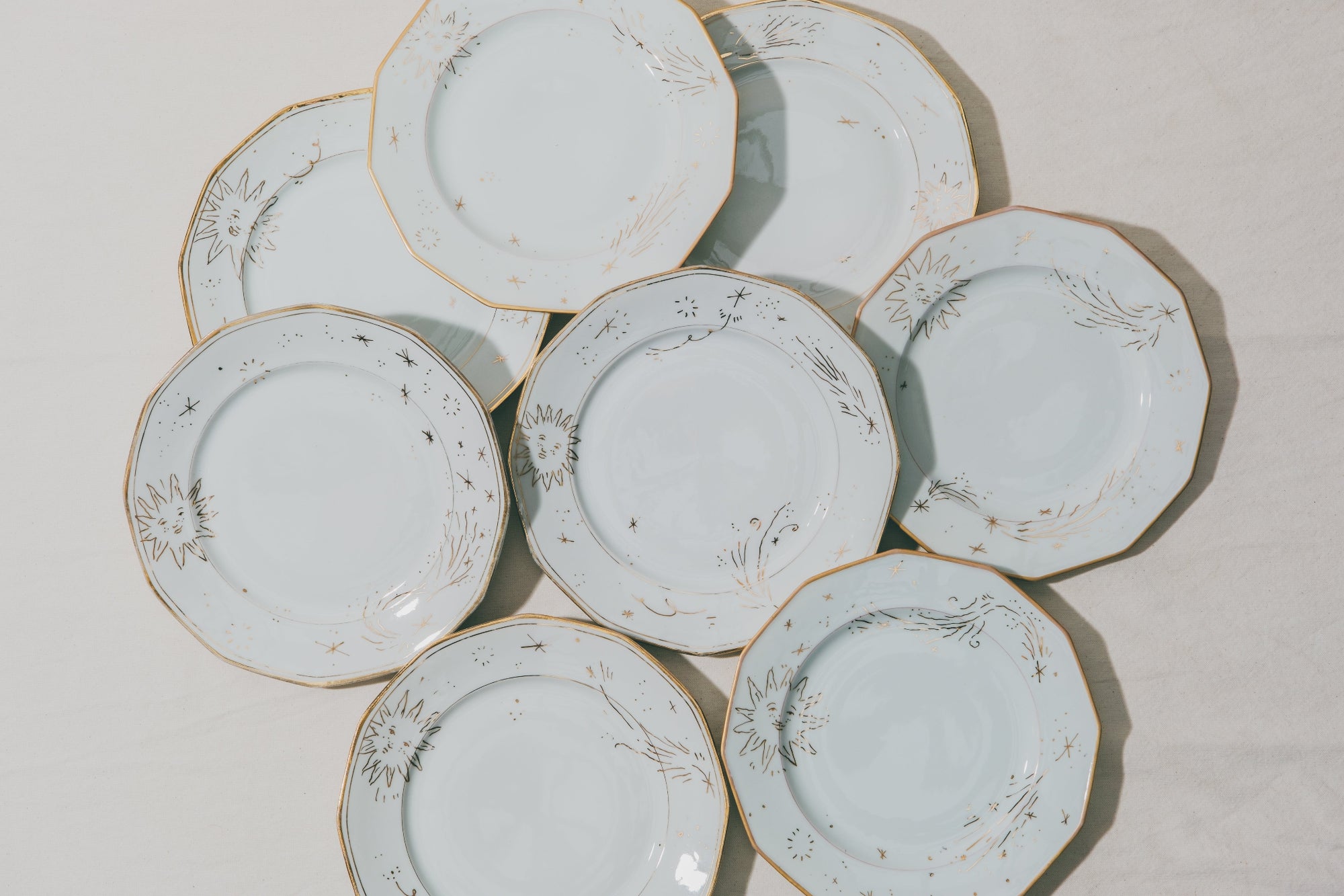 Assiettes en porcelaine vintage décorées à la main à l'or et à la plume par Arnold d'Alger à l'atelier Grand Soleil à Paris, personnalisables sur demande