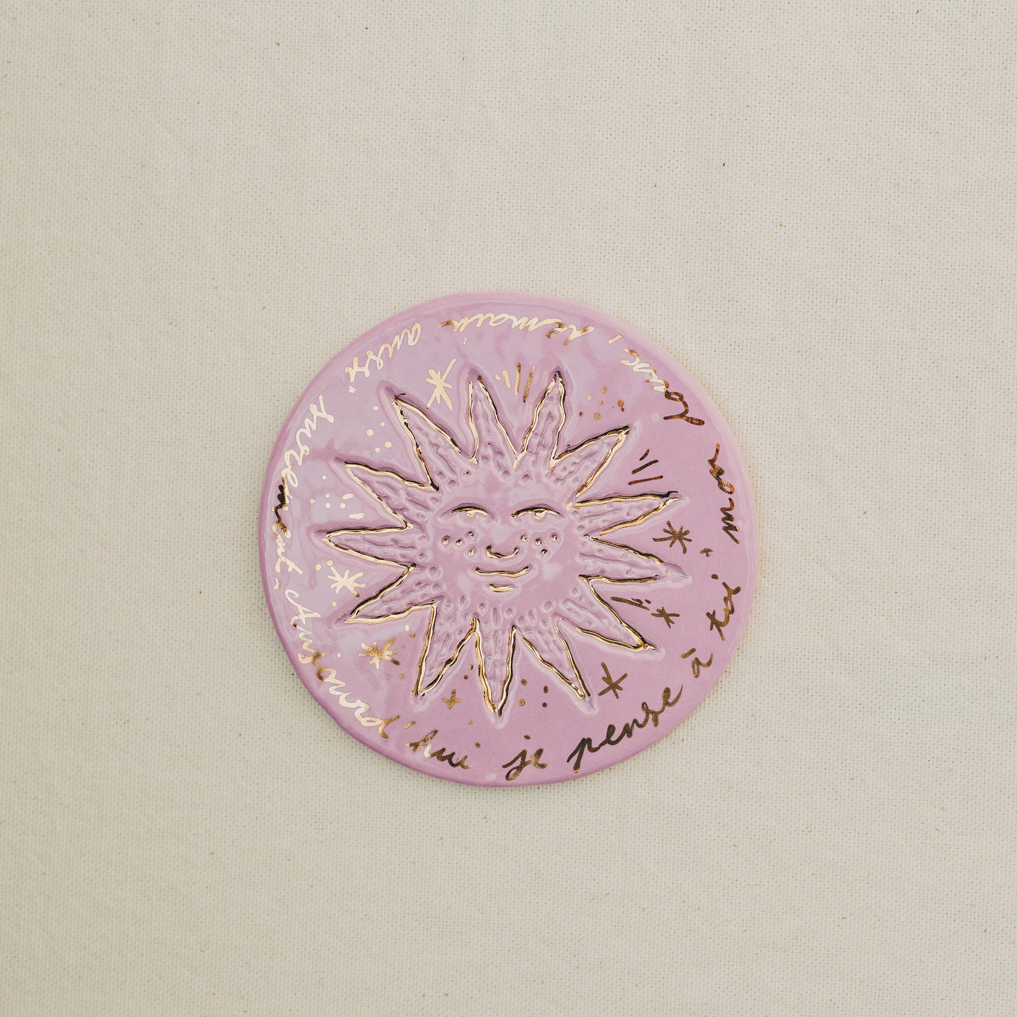Médaille petit soleil en faïence personnalisée à la main, à l'or et à la plume. Atelier grand soleil. Couleur : rose
