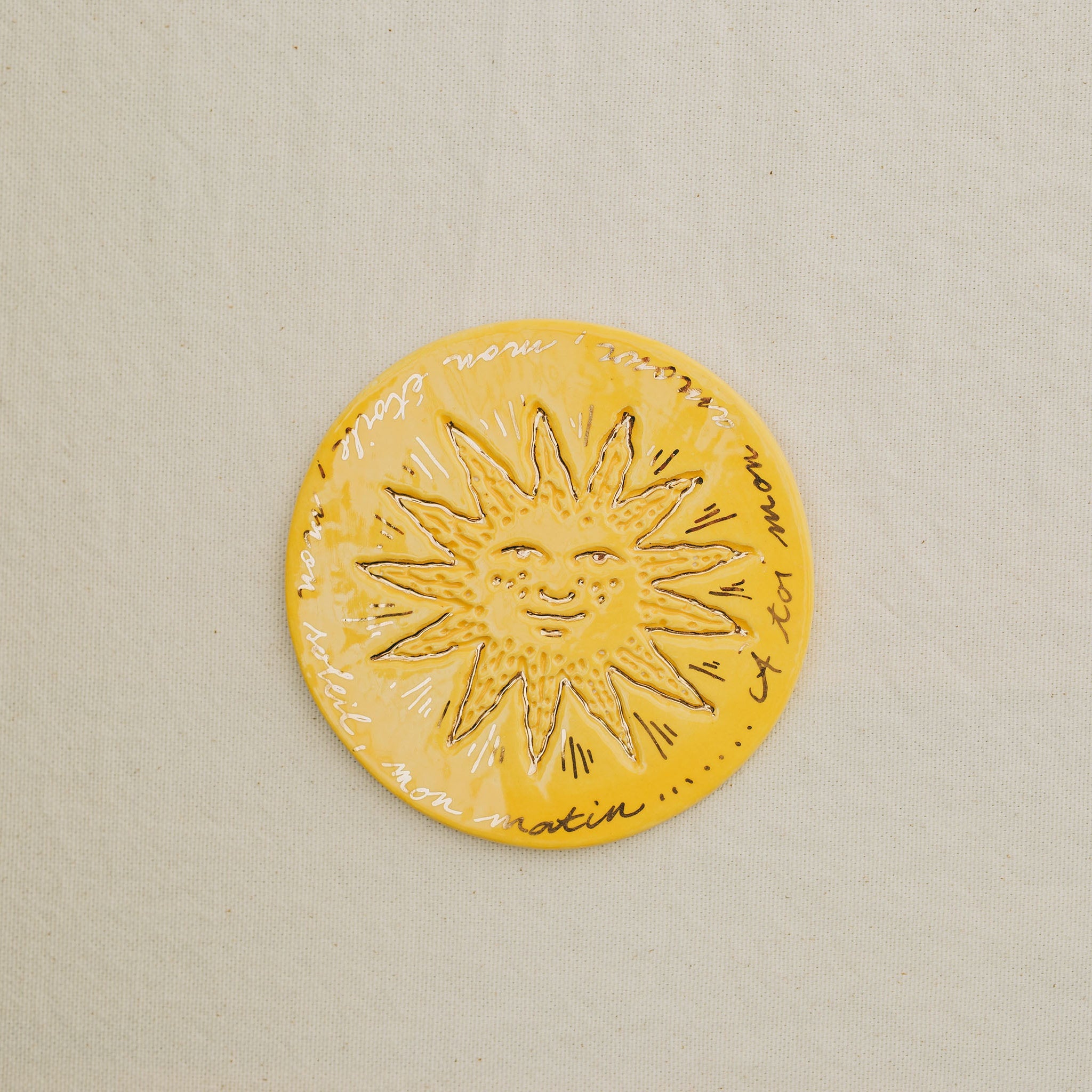 Médaille petit soleil en faïence personnalisée à la main, à l'or et à la plume. Atelier grand soleil. Couleur : citron
